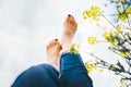 Happy female lying in deep yellow flowers meadow with bright sunny day optical sun beams flares. Happiness in nature concept Legs