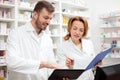 Happy female and male pharmacists working together in a pharmacy