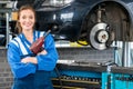 Happy Female Mechanic Holding Pneumatic Wrench By Car