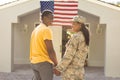 Happy female mid adult african american soldier holding hand of husband on arrival at home Royalty Free Stock Photo