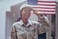 Happy female mid adult african american soldier in uniform standing outside house Royalty Free Stock Photo