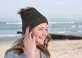 Happy female model wearing green knitted beanie with Bluetooth speakers