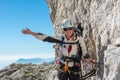 Happy female mountaineer climbing via ferrata.