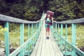 Happy female mountaineer standing on a wooden bridge over a mountain stream overflowing with excitement with the glory and beauty Royalty Free Stock Photo