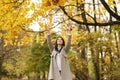 happy female office worker throws orange, yellow leaves up in autumn park. Stress relief. Royalty Free Stock Photo
