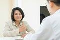 Happy female patient showing finger thumbs up during examination her health with doctor in clinic. Royalty Free Stock Photo