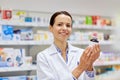 Happy female pharmacist with drug jar at pharmacy Royalty Free Stock Photo