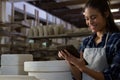 Happy female potter using digital tablet