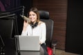 Happy female radio broadcaster hosting a live show