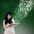 Happy female reading with alphabet letters coming out from book Royalty Free Stock Photo