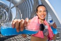 Happy female runner with energetic drinks for hydration