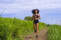 Happy female runner training on countryside road - young attractive and fit jogger woman doing running workout outdoors at Royalty Free Stock Photo