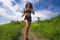 Happy female runner training on countryside road - young attractive and fit jogger woman doing running workout outdoors at Royalty Free Stock Photo