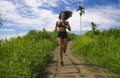 Happy female runner training on countryside road - young attractive and fit jogger woman doing running workout outdoors at Royalty Free Stock Photo