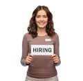 happy female shop assistant with hiring banner