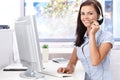 Happy female sitting at desk in bright office