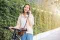 Happy female smiling walk at street with her bike on city road and cellphone with mobile phone Royalty Free Stock Photo