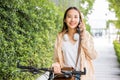 Happy female smiling walk at street with her bike on city road and cellphone with mobile phone Royalty Free Stock Photo