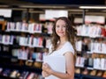 Happy female student holding books at the library Royalty Free Stock Photo