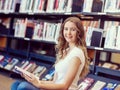 Happy female student holding books at the library Royalty Free Stock Photo