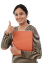 Happy female student holding text book Royalty Free Stock Photo