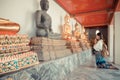 Happy female student kneeling in front of buddha