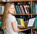 Happy female student with laptop in library Royalty Free Stock Photo