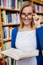 Happy female student reading a book in the library Royalty Free Stock Photo