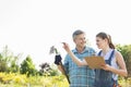 Happy female supervisor explaining something to gardener at plant nursery