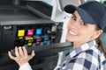 happy female technician changing ink cartridges printer Royalty Free Stock Photo