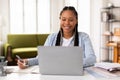 Happy female teen studying with laptop and taking notes, home interior Royalty Free Stock Photo