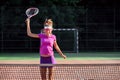 Happy female tennis player jumping near the net and laughing, celebrating her winning in tennis match. Sport, health Royalty Free Stock Photo