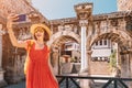 Female tourist traveller takes selfie photos against the backdrop of Hadrian`s gate - a popular attraction in the old city Royalty Free Stock Photo