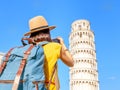 Female traveler in hat with backpack taking photo of the leaning tower in Pisa. Vacation and lifestyle concept Royalty Free Stock Photo