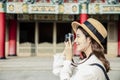 Happy female traveler photographing temples at Asia