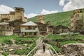 Happy female traveller in Ushguli,UNESCO site,Georgia.Backpacker exploring the Greater Caucasus mountains.Rural stone houses,