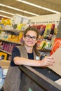 Happy female worker arranging cardboard packaging at supermarket