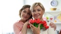 Happy females looking at camera holding tulip flowers, international womans day