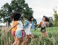 Happy females running on field enjoying summer journey