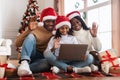 Happy festive black family using pc making videocall on Xmas Royalty Free Stock Photo