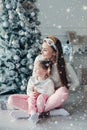 Happy festive mother and daughter hugging sitting together at decorating beautiful Christmas tree Royalty Free Stock Photo