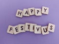 Happy festivus message on wood blocks on a purple background