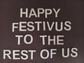 Happy festivus to the rest of us sign on a brown background