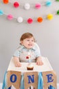 Happy first birthday cake smash. Happy smiling cute Caucasian baby boy celebrating his first birthday at home. Child kid toddler Royalty Free Stock Photo