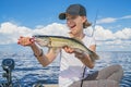 Happy fisher girl with walleye zander fish trophy at the boat Royalty Free Stock Photo