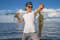 Happy fisher woman with zander fish trophy at the boat Royalty Free Stock Photo