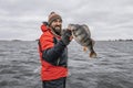 Happy fisherman with big perch fish trophy at boat Royalty Free Stock Photo