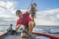 Happy fisherman with big perch fish trophy at boat Royalty Free Stock Photo