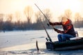 Happy fisherman catch fish on the frozen river in winter Royalty Free Stock Photo