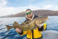 Happy fisherman with cod fish in hands Royalty Free Stock Photo